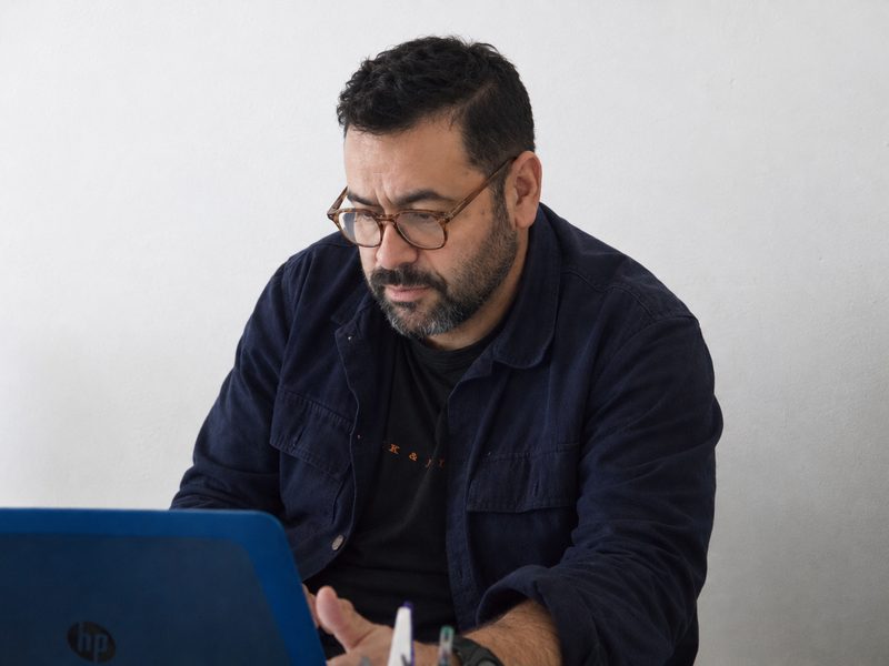 Portrait de Halim Bensoula, dirigeant de Bendebarras, devant un ordinateur portable